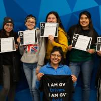 Eight students showing their I am GV certificates